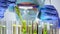 Chemist comparing test tube with green plant and blue liquid in flask, science