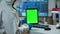 Chemist man wearing protection suit holding tablet with green mockup