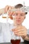 Chemist pours brown liquid in flask