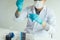 Chemist scientist conducts experiments by synthesising compounds with using dropper in a test tube