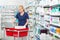 Chemist Using Laptop On Medicine Basket In