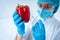 Chemist woman making laboratory analysis, holding syringe in hands, making injection in vegetable