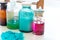 Chemistry bottles containing various substances of different colors standing on laboratory table seen over a pile of blue powder