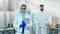 . In the chemistry laboratory two medical students woman and man posing in front of the camera they smiling large