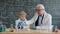 Chemistry professor and little child doing chemical test in school laboratory