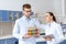 Chemists in white coats inspecting test tube with reagent in lab