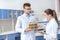 Chemists in white coats inspecting test tubes with reagents in lab