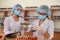 Chemists working in laboratory. Young women in protective uniforms with test tubes making experiments