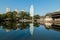 Chengdu cityscape with water reflecting buildings and clear sunlit sky, trees around