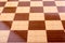 Chequered white and brown chess board on display