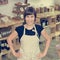 Cherfull young female shop owner posing in front of shelves full of healthy products.