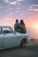 Cherish every sunset. a young couple making a stop at the beach while out on a road trip.