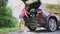 CHERKASSY, UKRAINE, JULY 16, 2021: vacuum in the car. young woman, in shorts and shirt, is cleaning car trunk with