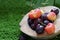 Cherries and fresh blueberries put in a cup made from coconut shells on the grass.