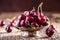 Cherries. Fresh sweet cherries. Delicious cherries with water drops in retro bowl on old oak table