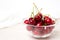 Cherries in glass dish. Cherry on wood and white background. - healthy eating and food concept