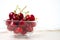 Cherries in glass dish. Cherry on wood and white background. - healthy eating and food concept