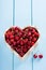 Cherries in a heart box on blue wooden table