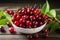 Cherries with leaves glisten in a white bowl on wooden backdrop