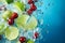 Cherries and lime in water with ice cubes on blue background