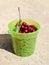 Cherries in a plastic green bucket. Ripe red sweet