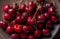 Cherries on a plate, on a wooden background. Summer picnic, harvest, treats. Food for vegetarians and vegans.