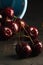 Cherries poured out of the cup against a dark background. Close-up