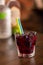 Cherry alcohol drink with color straw on wooden table