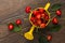 Cherry berries and cherry leaves on yellow garden watering container.