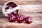 Cherry berries spilled out of a decorative basket on a wooden background. Crop of cherry berries