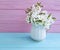 Cherry blossoming branch vase on a colorful wooden background