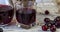 Cherry and cherry juice or wine on a wooden table, a decanter and a glass with juice, a basket with cherries