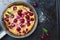 Cherry Dutch Baby, Puff German Pancake on Vintage Pans and Dark Background, Homemade Summer Dessert