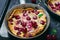Cherry Dutch Baby, Puff German Pancake on Vintage Pans and Dark Background, Homemade Summer Dessert