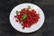 Cherry elaeagnus or gumi berries on dish on dark surface