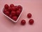 cherry flavored candies in a heart shaped ceramic bowl