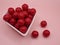 cherry flavored candies in a heart shaped ceramic bowl