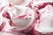 Cherry flavour gelato - full frame detail. Close up of a white surface texture of Cherry Ice cream covered with red stripes