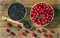 Cherry jam and red cherries in a basket on a wooden table.