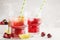 Cherry juice with ice and lime in a glass beaker, light background. White background.