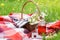 Cherry juice in mason jar and picnic basket with food, flowers