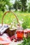 Cherry juice in mason jar and picnic basket with food, flowers