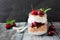 Cherry parfait in a mason jar with a dark rustic background