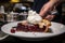 cherry pie being served on bistro-style plate, with dollop of whipped cream and a sprinkle of cinnamon