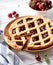 Cherry pie with lattice crust on white wooden background