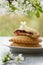 Cherry pies on saucer in spring composition on wooden background