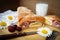 Cherry strudel on a wooden board with cherry berries and field daisies and a glass of milk