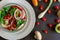 Cherry tomato salad, with mushrooms, onion on a black table, with some patterns