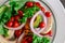 Cherry tomato salad, with mushrooms, onion on a black table, with some patterns