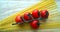 Cherry tomatoes on the branch with spaghetti,wooden background